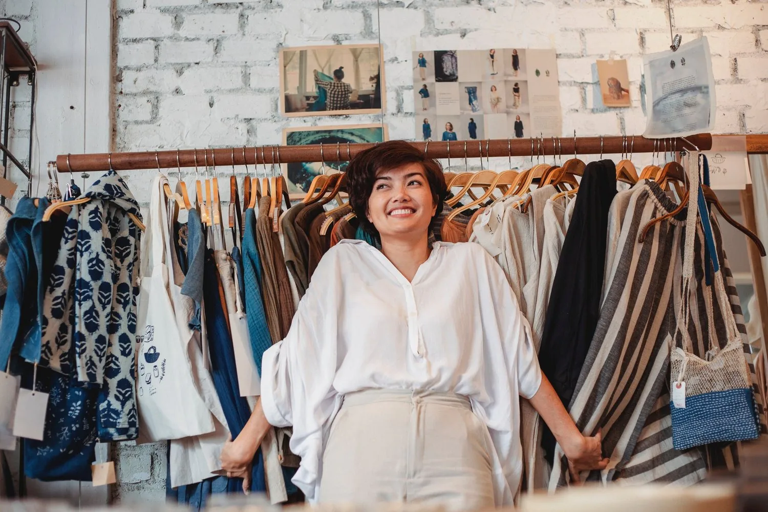 women smiling in front of a rack of clothes